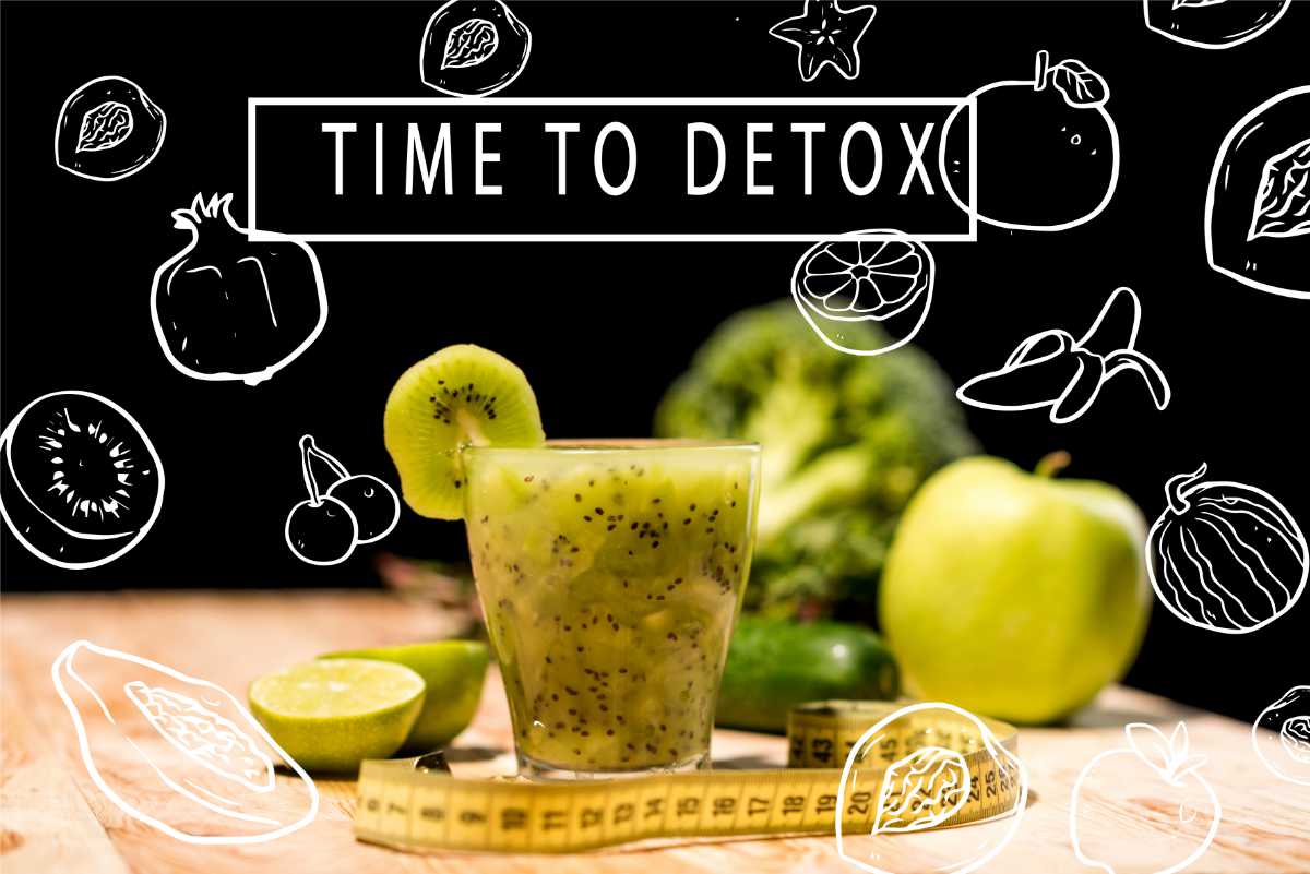 Ein grüner Smoothie umgeben von Obst und einem Maßband mit der Aufschrift TIME TO DETOX auf schwarzem Hintergrund.